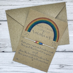 May include: A white string bracelet with rainbow coloured beads and a card that says "When it rains look for rainbows. Close your eyes and make a wish then put this bracelet on your wrist, when the bracelet breaks in two, then your wish will come true." @minniepiesigns handmade in devon