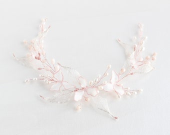 May include: A delicate floral hair comb with pink and white flowers and pearl accents. The comb is made of metal and has a wire design.