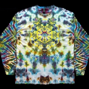 May include: A long-sleeve crew neck shirt featuring a vibrant tie-dye pattern in shades of blue, green, purple, and brown. The center of the chest displays a prominent, intricate yellow mandala design with symmetrical, circular, and floral-like motifs.