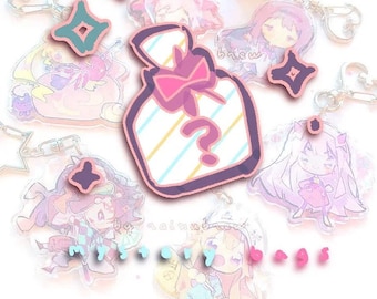 May include: A collection of colorful anime character keychains with a pink and white striped gift bag keychain with a question mark. The keychains are made of clear acrylic and have a shiny finish.