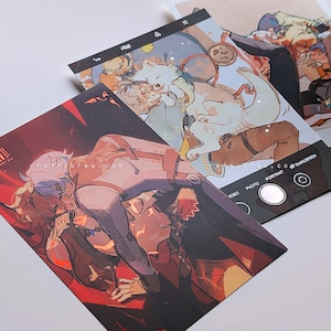 以下が含まれることがあります： アニメスタイルのイラストが描かれた3枚のアートプリント。1枚は赤と黒の背景に白と紫の衣装の人物が描かれています。もう1枚は、人物と動物が登場する水色と白のシーンです。3枚目は黒い縁取りです。