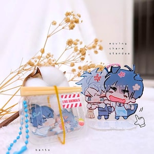 May include: A clear acrylic bento shaker charm and standee featuring anime-style characters with blue hair. The shaker charm has a blue beaded chain and the text "LIVE ANIMALS". The standee has the text "moving charm standee".