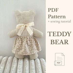 May include: A handmade teddy bear made of beige fabric, wearing a floral skirt and a cream-colored lace bow. The image includes the text "PDF Pattern + sewing tutorial" and "TEDDY BEAR".
