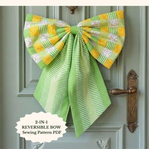 May include: A large, handmade reversible bow in shades of green and yellow hangs on a door. The bow features a patchwork design with yellow squares and green stripes. The bow is made from fabric and is designed to be reversible. The text "2-IN-1 REVERSIBLE BOW Sewing Pattern PDF" is visible.