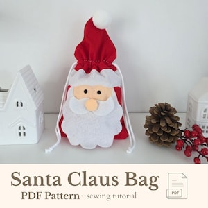 May include: A red Santa Claus bag with a white felt face, beard, and hat trim. The bag has a drawstring closure and a white pom-pom on the hat. The text "Santa Claus Bag" is displayed at the bottom.