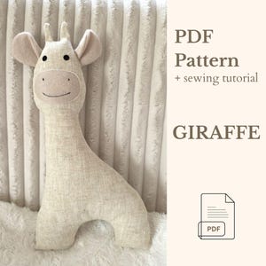 Puede incluir: Un peluche de jirafa beige con una cara sonriente, orejas pequeñas y cuernos. La jirafa está hecha de tela suave y está sentada sobre una superficie blanca y texturizada. El texto a la derecha dice "PDF Pattern + sewing tutorial" y "GIRAFFE".