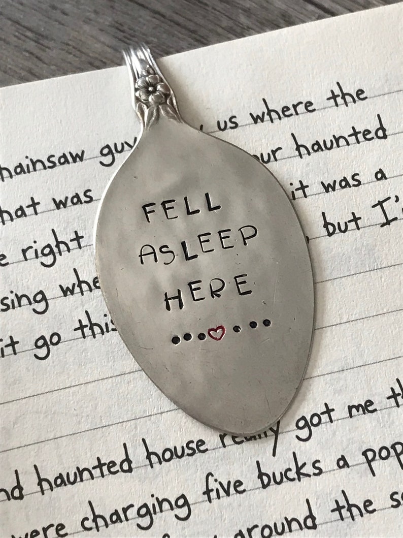 May include: A silver spoon with the words "FELL ASLEEP HERE" engraved on it. The spoon has a small red heart in the middle of the text.