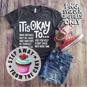 May include: A gray t-shirt with the text "It is okay to..." and a list of phrases including "make mistakes", "not be okay", "have hard days", "ask for help", "be yourself", "start over", "not know it all", and "need more time". Below the text is a circle with the text "Step away from the cake" and a cupcake with pink frosting and green sprinkles.