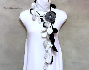 Bufanda de crochet con lazo: hojas negras, grises y blancas con broche de flor gris
