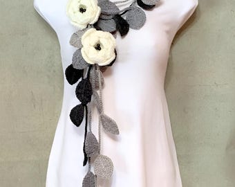 Lazo de crochet: broches de flores blancas, bufanda de hojas grises