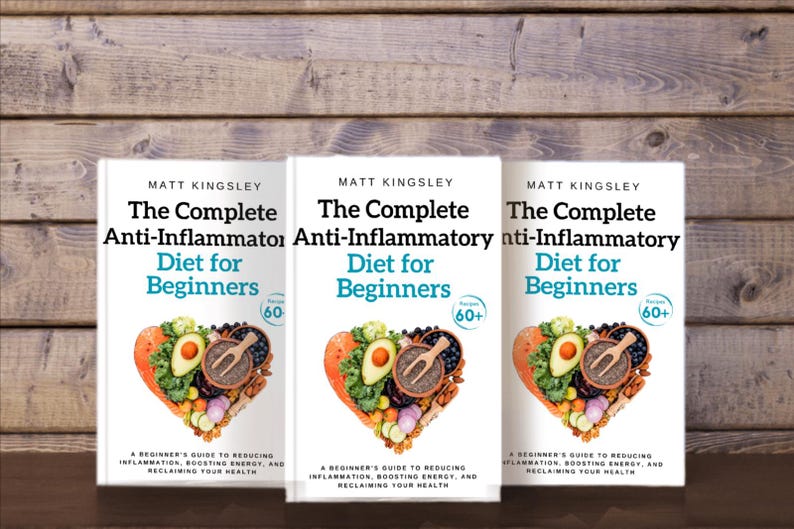 Puede incluir: Tres portadas de libros id&eacute;nticas con un fondo blanco y el t&iacute;tulo "The Complete Anti-Inflammatory Diet for Beginners" en texto negro. Las portadas de los libros presentan una disposici&oacute;n en forma de coraz&oacute;n de frutas y verduras coloridas.