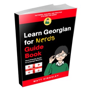 May include: A paperback book titled Learn Georgian for Nerds Guide Book by Matt Kingsley. The black cover features red accents, the Georgian flag, and an illustration of a person in a green sweater adjusting glasses. Text includes Patterns, Phrases, and Practice Systems for Nerds and Nerd-Friendly Guide to Language Mastery.