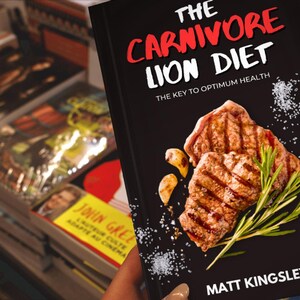 Puede incluir: Un libro negro con el t&iacute;tulo "The Carnivore Lion Diet: The Key to Optimum Health" en letras blancas y rojas. La portada presenta un primer plano de carne a la parrilla con romero y sal.