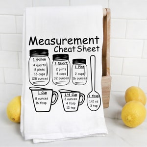 May include: Black and white kitchen towel with a measurement cheat sheet. The sheet includes measurements for gallons, quarts, pints, cups, and tablespoons. The text reads "Measurement Cheat Sheet".