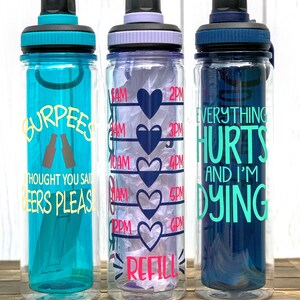 K&ouml;nnte beinhalten: Drei Wasserflaschen mit motivierenden Spr&uuml;chen. Die blaue Flasche sagt "Burpees Thought You Said Beers Please". Die klare Flasche hat Herz- und Zeitmarkierungen und sagt "Refill". Die dunkelblaue Flasche sagt "Everything Hurts And I'm Dying".