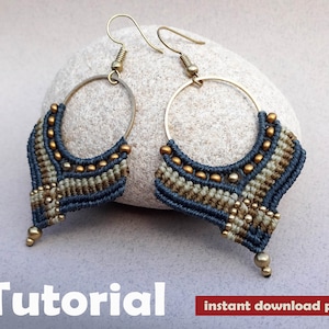 May include: A pair of blue and gold macrame earrings with a geometric design. The earrings are hanging from gold hoops and have a beaded detail. The earrings are on a grey background. Tutorial instant download pdf.