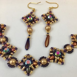 May include: A set of gold and purple beaded jewelry featuring a bracelet and earrings. The bracelet has five square-shaped bead clusters with a gold bead in the center of each cluster. The earrings have a similar design with a gold bead and a teardrop-shaped bead hanging below.