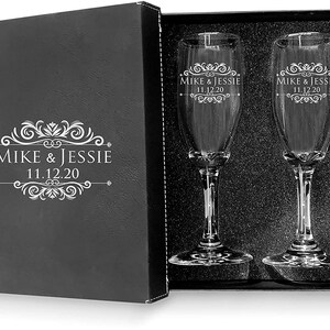 May include: Two engraved champagne flutes in a black gift box. The flutes are etched with the names "Mike & Jessie" and the date "11.12.20".