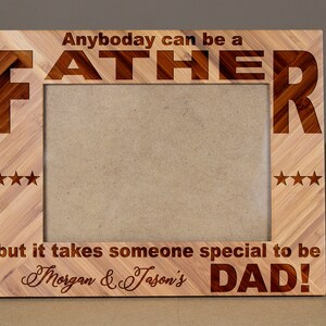 May include: Wooden picture frame with the words "Anybody can be a FATHER" and "but it takes someone special to be Morgan & Jason's DAD!" engraved on it. The frame has a light brown color and three stars on each side.