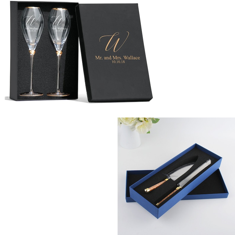 May include: Two champagne flutes in a black box with the text "Mr. and Mrs. Wallace 10.10.18" and a cursive "W" on the box lid. A blue box with a white interior contains a cake knife and server with gold handles.