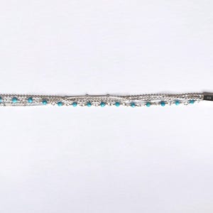 May include: A silver bracelet with multiple chains and turquoise beads.
