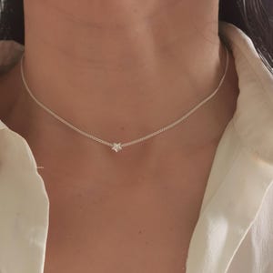 May include: A silver chain necklace with a small star pendant.