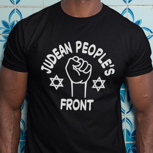 May include: Black t-shirt with a white graphic of a fist with the text "Judean People's Front" and two Star of David symbols.