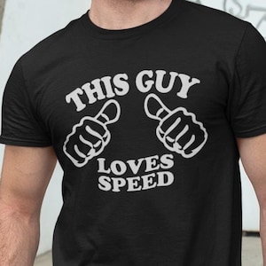 Puede incluir: Una camiseta negra con texto blanco que dice "This Guy Loves Speed" y dos pulgares hacia arriba.