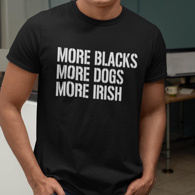 May include: Black t-shirt with white text that reads "More Blacks More Dogs More Irish".