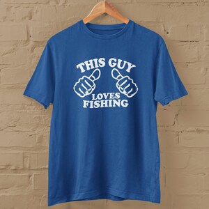 May include: A royal blue t-shirt with white text that reads "This Guy Loves Fishing" and two thumbs up symbols.