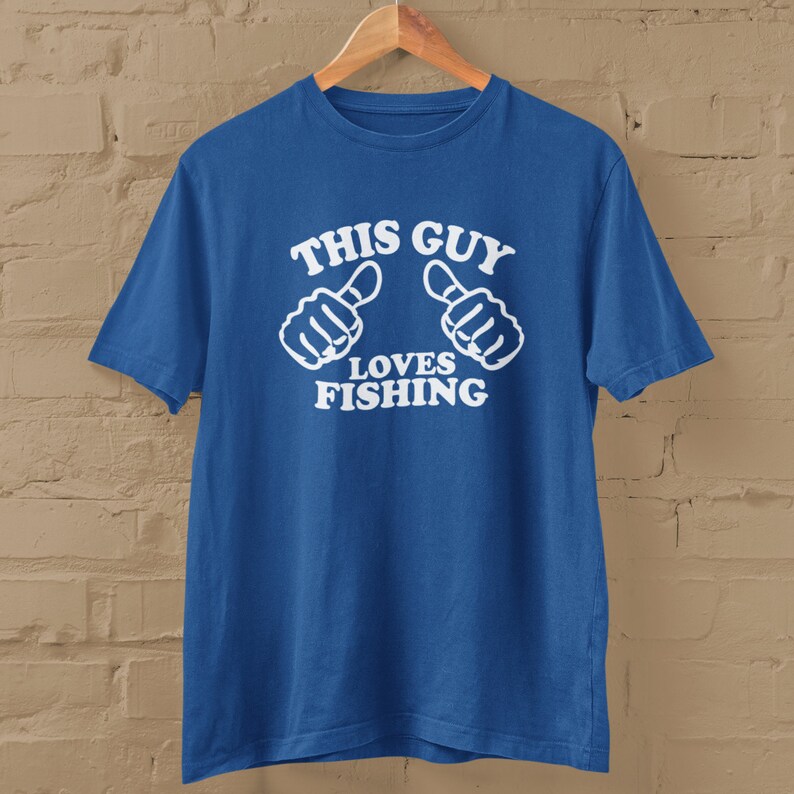 May include: A royal blue t-shirt with white text that reads "This Guy Loves Fishing" and two thumbs up symbols.