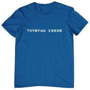 Op de afbeelding: Een koninklijk blauw t-shirt met de tekst "?SYNTAX ERROR" in wit.
