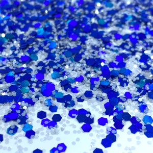 May include: A close-up of blue and silver glitter, with a mix of hexagonal and round shapes.