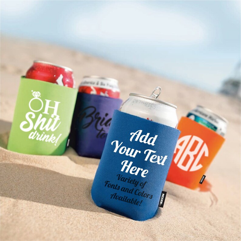 Puede incluir: Cuatro enfriadores de latas de diferentes colores con varios textos impresos en ellos. Los enfriadores est&aacute;n sobre un fondo de playa de arena. El texto en los enfriadores dice "Oh Shit drink!" "Bride to Be" "Add Your Text Here" y "ABC".