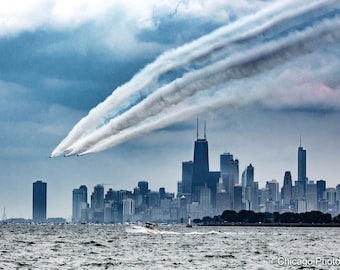 May include: A view of the Chicago skyline with a group of aeroplanes flying in formation leaving white smoke trails in the sky.