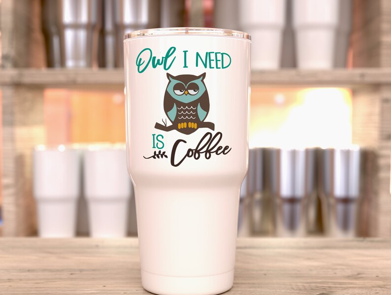 May include: White stainless steel tumbler with a teal, brown, and yellow owl graphic and the text "Owl I need is coffee".