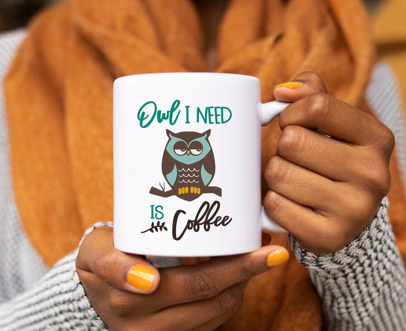 May include: White ceramic mug with a green, brown, and blue owl illustration and the text "Owl I need is coffee".