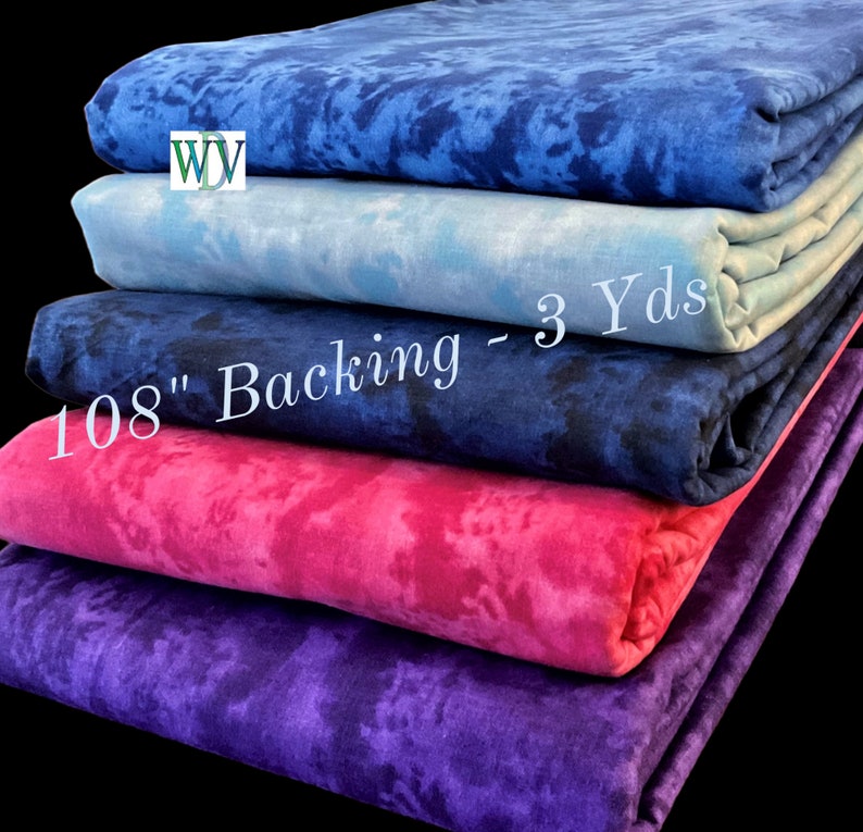 May include: Stack of five fabric squares in different shades of blue, pink, and purple. The fabric has a tie-dye pattern. The text "108" Backing - 3 Yds" is visible on the fabric.
