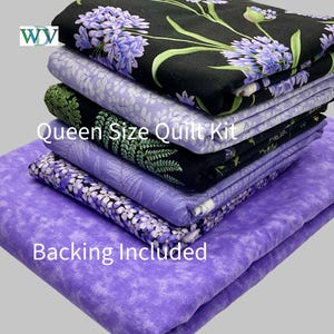May include: A stack of folded fabric pieces for a Queen Size Quilt Kit with Backing Included. The fabrics feature various patterns including purple floral prints on black and light purple backgrounds, and green fern leaves on a black background.