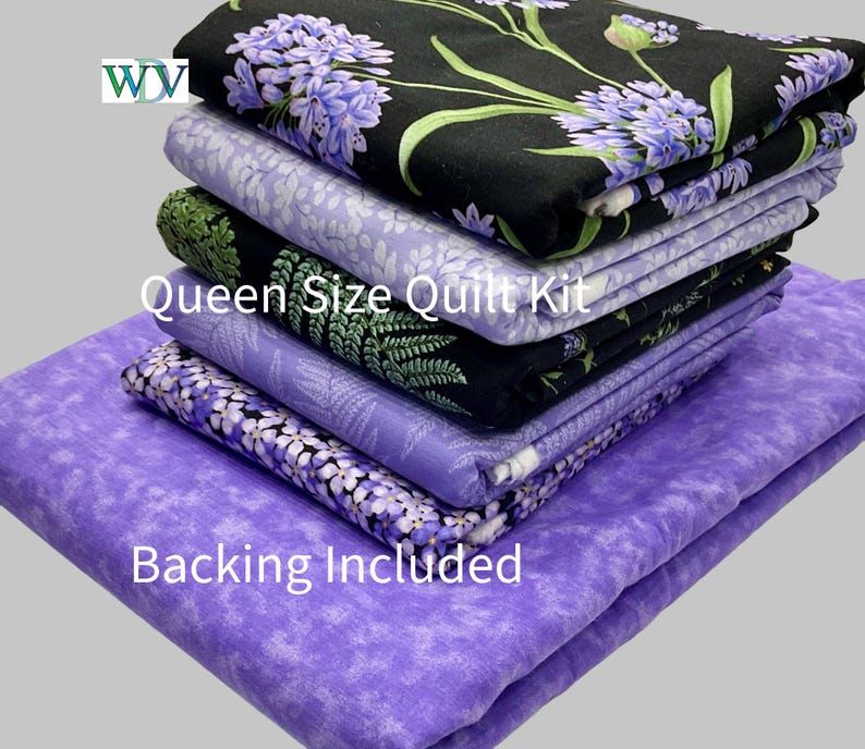 May include: A stack of folded fabric pieces for a Queen Size Quilt Kit with Backing Included. The fabrics feature various patterns including purple floral prints on black and light purple backgrounds, and green fern leaves on a black background.