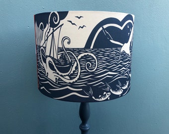 Lampshade featuring a costal design of ships and sea creatures.