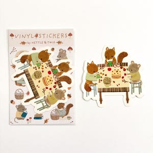 May include: Vinyl stickers with an autumnal theme, depicting squirrels and mice at a table with food. The stickers feature warm colours and the text "Vinyl Stickers by Nettle & Twig".