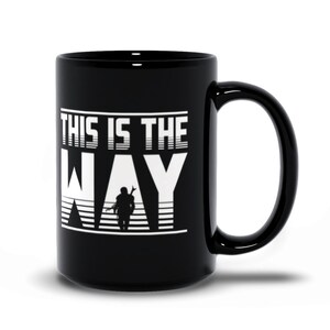 Puede incluir: Taza de caf&eacute; de cer&aacute;mica negra con un gr&aacute;fico blanco que dice "This is the Way" con una silueta de un personaje mandaloriano en el medio de la palabra "Way".