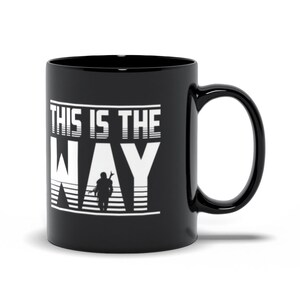 Puede incluir: Taza de caf&eacute; de cer&aacute;mica negra con un gr&aacute;fico blanco que dice "This is the Way" con una silueta de un personaje mandaloriano en el medio de la palabra "Way".