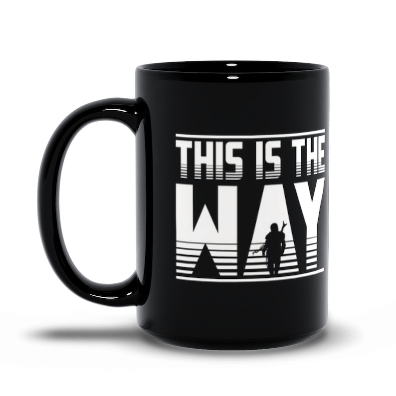 Puede incluir: Taza de caf&eacute; de cer&aacute;mica negra con un gr&aacute;fico blanco de una figura con el texto "This is the Way" en estilo retro.