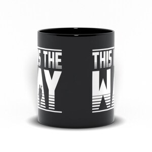 Puede incluir: Taza de cer&aacute;mica negra con texto blanco que dice "This is the Way" con una silueta de una persona en el fondo.