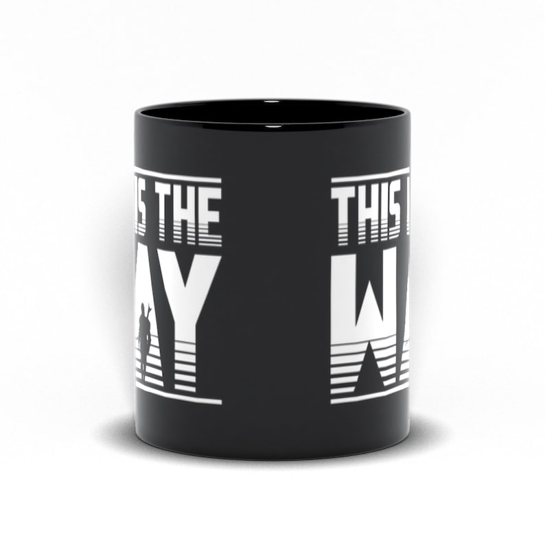 Puede incluir: Taza de cer&aacute;mica negra con texto blanco que dice "This is the Way" con una silueta de una persona en el fondo.
