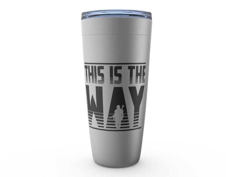 Puede incluir: Una taza de viaje plateada con un gr&aacute;fico negro que dice "This is the Way" con una silueta de un personaje mandaloriano.