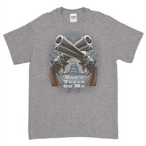 May include: A gray t-shirt with a graphic of two crossed revolvers and the text "Don't Tread On Me".