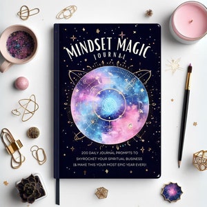 May include: A black journal with a galaxy design and gold accents. The cover reads "Mindset Magic Journal" and "200 Daily Journal Prompts to Skyrocket Your Spiritual Business (& Make This Your Most Epic Year Ever)!".